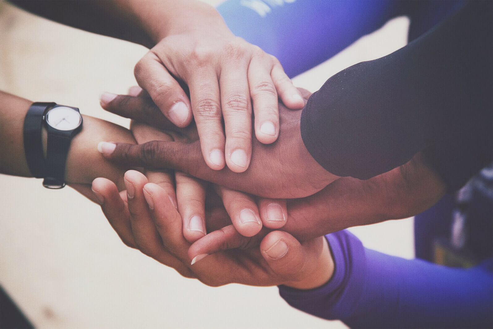 Racially-diverse group of clasped hands Racially-diverse group of clasped hands